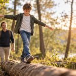 Positives Mindset bei Kindern stärken: 10 Wege für mehr Mut, Selbstvertrauen und Lernfreude Positives Mindset bei Kindern stärken – Junge balanciert selbstbewusst auf einem Baumstamm